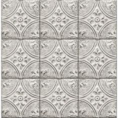 a white tile wall with an intricate design