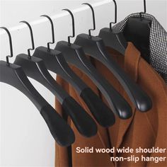 black clothes hangers are hanging on a white coat rack with the words solid wood wide shoulder non - slip hanger