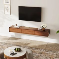 a flat screen tv mounted to the side of a wall above a wooden entertainment center