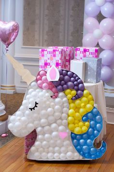 an inflatable unicorn is on the floor with balloons