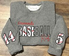 a sweatshirt with the number 54 on it is sitting on a wooden floor and has red writing that reads coronada baseball