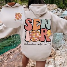 a woman wearing a white hoodie with the words sein lor class of 202 printed on it