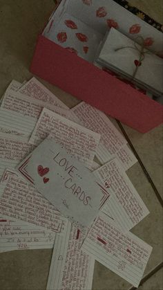 several pieces of paper that are on the floor next to a box with love notes