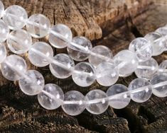 some clear beads are laying on a piece of wood