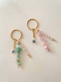 two keychains with beads and charms on them sitting next to each other in front of a white surface