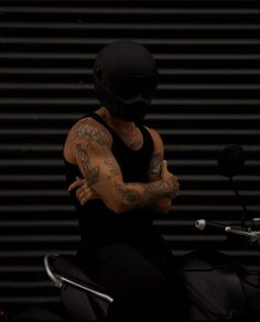 a man with tattoos sitting on a motorcycle