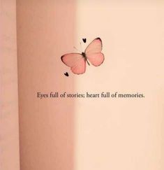 a pink butterfly flying in the air next to a wall with a quote on it