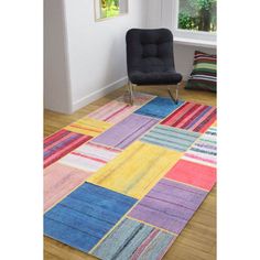 a colorful area rug in a living room with a chair and table next to it