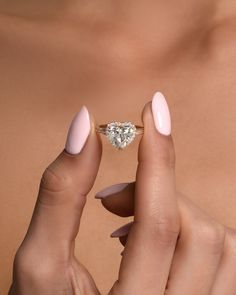 a woman's hand holding an engagement ring with a diamond on the middle finger