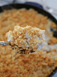 a spoon full of ice cream and crumbs in a skillet with other items