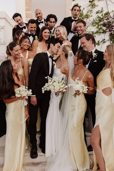 a group of people standing next to each other in front of a staircase with flowers