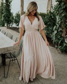 Say hello to our fabulous Delilah Maxi Dress in Blush. This dress is oh so gorgeous and you will not want to miss out! Fitted V-neck Maxi Dress With Elastic Waistband, Bohemian V-neck Dress With Smocked Back, V-neck Beach Dress With Elastic Waistband, Bohemian V-neck Dress With Smocked Bodice, Brunch Maxi Dress With Smocked Back And Flowy Skirt, Feminine Blush V-neck Maxi Dress, Blush Fitted V-neck Maxi Dress, Flowy Maxi Length V-neck Dress For Day Out, Flowy V-neck Maxi Dress For Day Out