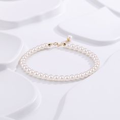 Embrace timeless grace with our Dainty Pearl White Freshwater Bracelet. Featuring delicate 4-5mm pearls, this bracelet captures a classic elegance that's both subtle and enchanting. Perfectly strung to rest effortlessly on your wrist, the small-sized pearls provide a refined touch that's suitable for any occasion. Whether worn alone or paired with other pieces, this dainty bracelet embodies pure sophistication. It's a beautiful reminder that true elegance often lies in simplicity. Pearl size 4-5 Elegant Adjustable Hand-strung Pearl Necklace, Timeless White Gold Pearl Bracelet For Anniversary, Timeless White Gold Pearl Bracelet, Akoya Pearl Bracelet With Round Beads And Pearl Charm, Akoya Pearl Charm Bracelet With Round Beads, Single Strand Akoya Pearl Bracelet In Pearl White, Classic Pearl Drop Bracelet For Wedding, Elegant Yellow Gold Cuban Link Bracelet, Timeless White Gold Pearl Bracelet For Wedding