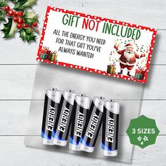 four batteries and a christmas gift card on a table