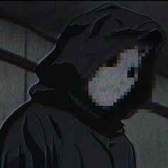 a man wearing a hooded jacket and looking at something on his face in the dark