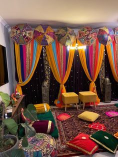 a living room filled with lots of furniture and colorful drapes hanging from the ceiling