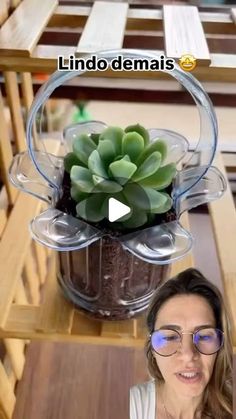 a woman sitting at a table with a potted plant