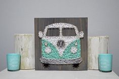 a string - wrapped vw bus sits on a table next to two mugs