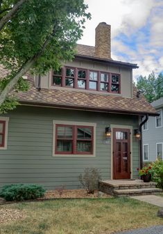 a gray house with red trim and windows