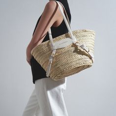 Beige and white raffia tote bag from Givenchy. The Plage Voyou tote bag is made of hand-crafted raffia, featuring transversal leather straps with gold and silver-finish Givenchy engraved metal buckles, along with white leather handles offering a practical long shoulder carry. It is complete with one main compartment.Measurements: L42 x H22 x W16 cmMade in Italy Raffia Tote Bag, Engraved Metal, Metal Engraving, Leather Handles, White Bag, Metal Buckles, Leather Handle, Gold And Silver, White Leather