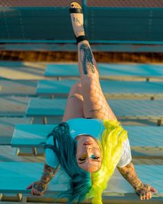 a woman with green hair is upside down on the ground