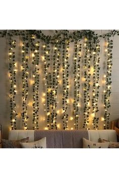 a living room filled with lots of lights and greenery hanging from the wall above it