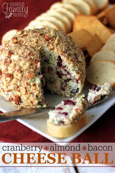 a white plate topped with a cheese ball covered in cranberry sauce next to crackers