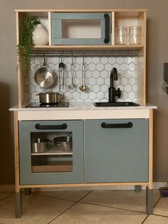 a toy kitchen with pots and pans on the shelves