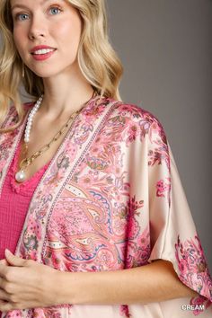 The Satin Breeze Border Print Kimono is an elegant and lightweight layering piece that adds a touch of sophistication to any outfit. Crafted from 100% polyester, this kimono features a smooth, silky satin finish that drapes beautifully over the body. The open front design allows for effortless styling, while the intricate border print adds a touch of artistry and visual interest. Short sleeves make it perfect for warmer weather, and the flowy silhouette enhances its relaxed, bohemian vibe. Fit & Chic Satin Wrap Kimono, Spring Satin Kimono With Floral Print, Spring Satin Kimono With Kimono Sleeves, Floral Print Satin Kimono, Spring Floral Print Satin Kimono, Satin Kimono With Floral Print, Elegant Wrap Kimono With Floral Print, Elegant Floral Print V-neck Kimono, Elegant Open Front Kimono For Spring