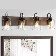 three light bathroom fixture with clear glass jars on the front and back of the lights