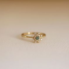 a close up of a ring on a white surface with a small diamond in the middle