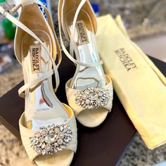 a pair of white shoes sitting on top of a table next to a yellow bag