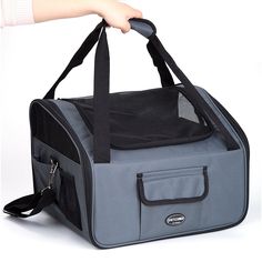 a person is holding onto a gray and black pet carrier with its front pocket open