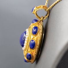 The contrast in color of this locket is exquisite, and it is impeccably made. The locket features cabochons of natural lapis lazuli, with the center cab surrounded in a frame of seed pearls. This is a picture locket with a window on the back which can be opened and a photo inserted. It features a really wide bail so that the piece can be worn over large chains or silk ribbon. The locket is crafted in 18k (x ray tested) and weighs 14.82g. It measures just under 1 3/4" in height and is just over 1" across in width. The chain is not included. Lapis And Pearl, Pearl Locket, Picture Locket, Seed Pearl, X Ray, Silk Ribbon, A Frame, Lapis Lazuli, Locket