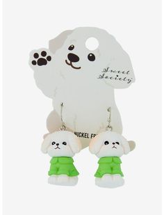 two small white dogs wearing green clothes are hanging from the earring hooks in front of a white background