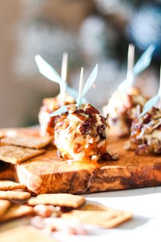 several appetizers are sitting on a cutting board with toothpicks sticking out of them