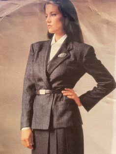 Loose-fitting, lined, above hip, wrap jacket has notched collar, slightly extended shoulders, side panels, welt and buttonhole pockets and long, two piece sleeves with mock vent and button trim.  Straight skirt, above ankle, has back button waistband, side front pleats and back zipper.  Very loose fitting blouse  has collar, extended shoulders, back pleated into yoke with slightly forward shoulder seams, pockets, flaps, shaped hemline and long sleeves with placket pleats and button cuffs. The pattern is complete with instructions.  The skirt portion is neatly cut, and the rest of the pattern is uncut. The envelope has some wear at the edges. Classic Tailored Long Sleeve Skirt Suit, Classic Long Sleeve Skirt Suit For Tailoring, Classic Long Sleeve Skirt Suit For Career, Classic Tailored Skirt Suit With Suit Collar, Classic Notch Lapel Skirt Suit With Buttons, Classic Skirt Suit With Notch Lapel, Classic Skirt Suit For Fall Formal Occasions, Classic Skirt Suit For Formal Fall Occasions, Classic Fall Skirt Suit For Formal Occasions