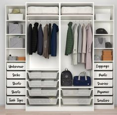 an organized closet with white shelves, drawers and clothes hanging on the wall next to it