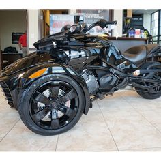 a black motorcycle parked in a showroom with no one on it's seat