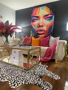 a living room filled with furniture and a painting on the wall above it's coffee table