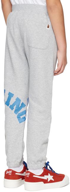 Cotton fleece sweatpants. · Elasticized waistband and cuffs · Single-pocket styling · Logo and graphic printed at leg · Logo flag at back pocket · Machine-wash Supplier color: Gray Model measures 56.5 / 142 cm tall and wears a size 140. BAPE Size: child's height 70: 25.5-29.5 / 65-75 cm 80: 29.5-33.5 / 75-85 cm 90: 33.5-37.5 / 85-95 cm 100: 37.5-41.5 / 95-105 cm 110: 41.5-45.5 / 105-115 cm 120: 45.5-49 / 115-125 cm 130: 49-53 / 125-135 cm 140: 53-57 / 135-145 cm 150: 57-61 / 145-155 cm 160: 61-6 Casual Jogging Bottoms With Logo Print, Cotton Jogging Bottoms With Logo Print, Cotton Bottoms With Logo Print For Jogging, College Sweatpants, Bape Kids, Fleece Sweatpants, Cotton Fleece, Kids Shop, Sweatpants