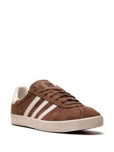 Adidas Gazelle 3-Stripes Leather Sneakers - Farfetch Brown Casual Sneakers With Three Stripes, Casual Brown Sneakers With Three Stripes, Brown Adidas Sneakers With Branded Insole, Brown Sporty Sneakers With Three Stripes, Sporty Brown Sneakers With Three Stripes, Brown Adidas Sneakers With Rubber Sole, Sporty Brown Sneakers With Three Stripes Branding, Classic Brown Adidas Sneakers, Brown Sneakers With Three Stripes And Round Toe