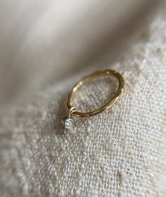 These are super delicate 1mm wide sleeper huggie style hoops in solid 9ct yellow gold. they have a very pretty subtle hammered texture which really catches the light. The hoops are 10mm across internally.  Hanging below the hoop is a 1.5mm natural genuine diamond charm made in Sterling silver.  These hoops are great if you want a subtle look when worn alone and they also stack so well in a curated ear look.    The hoops are available to buy as a single or a pair of hoops.  If you require more of this item than is showing as available to purchase please send me a message and I can advise on if I have more available.  All of my items are handmade by myself in my workshop in Surrey, England.  They come well packaged in a branded gift box and would make a lovely gift.  If you like one of my de Curated Ear, Surrey England, Tiny Diamond, Diamond Charm, Lovely Earrings, Charm Set, Dainty Earrings, Gold Hoops, Diamond Heart