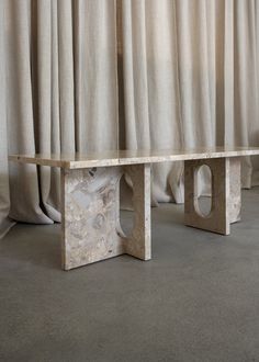 a marble bench sitting in front of a curtain