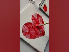 someone is painting a heart on a piece of paper