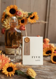 a table with sunflowers and wine glasses on it