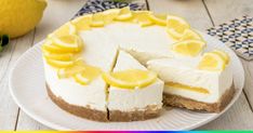 a white plate topped with a cheesecake covered in lemons and sliced into slices