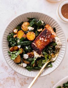 a white bowl filled with salad and meat