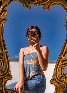 a woman taking a selfie in front of a mirror with her cell phone up to her face