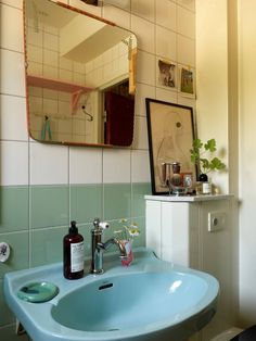 a blue sink in a bathroom under a mirror